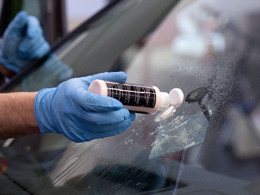 Ein Steinschlagschaden in der Frontscheibe wird repariert