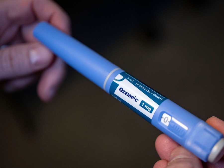 Hände halten einen Injektionspen