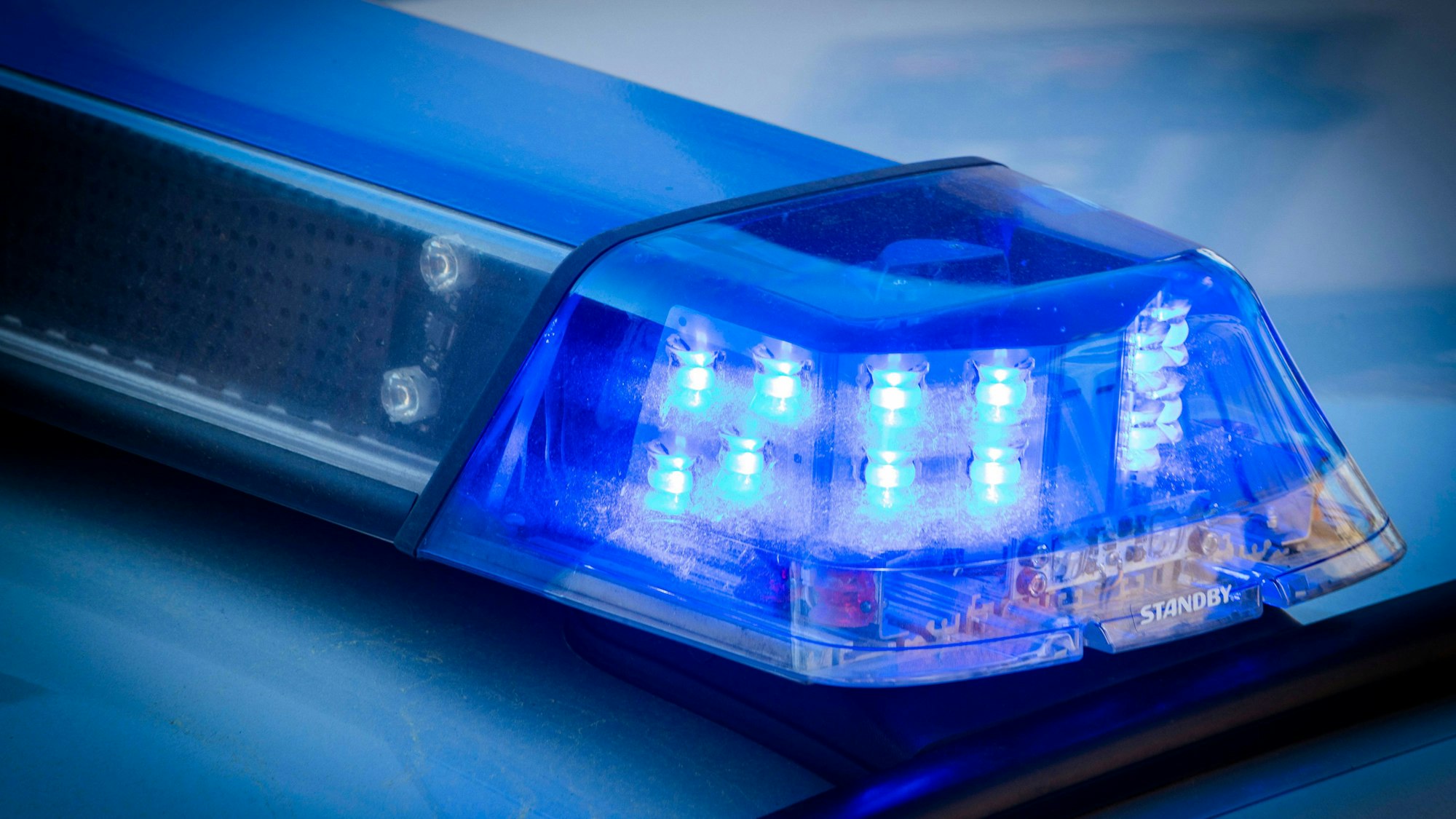 Leuchtender Blaulichtbalken eines Polizeiautos