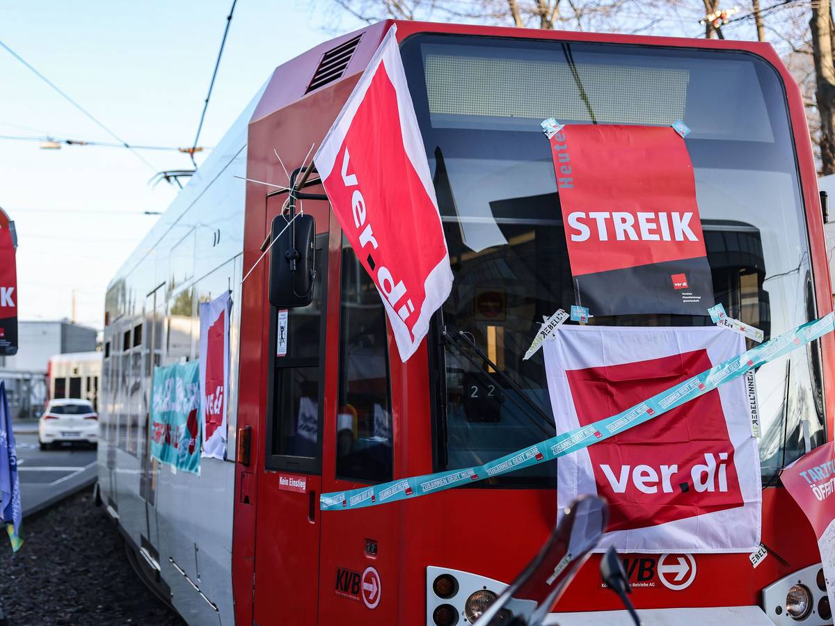 Eine mit Streik-Plakaten beklebte Straßenbahn der Kölner Verkehrs-Betriebe (KVB) steht vor dem Bahndepot.