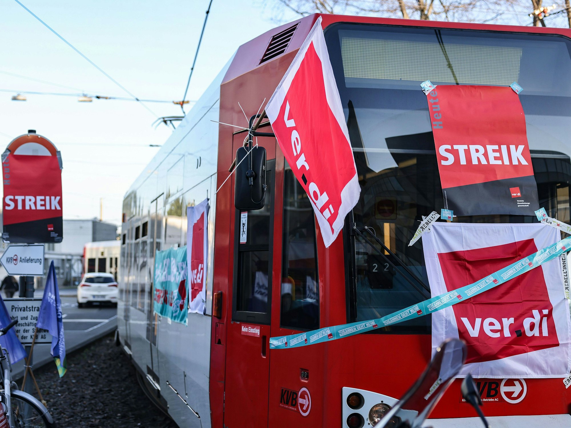 Eine mit Streik-Plakaten beklebte Straßenbahn der Kölner Verkehrs-Betriebe (KVB) steht vor dem Bahndepot.