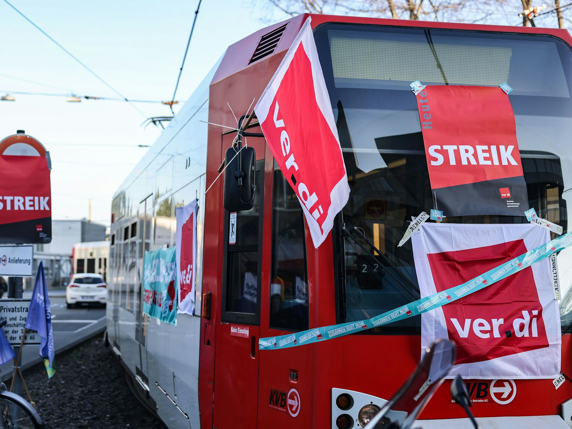 Eine mit Streik-Plakaten beklebte Straßenbahn der Kölner Verkehrs-Betriebe (KVB) steht vor dem Bahndepot.