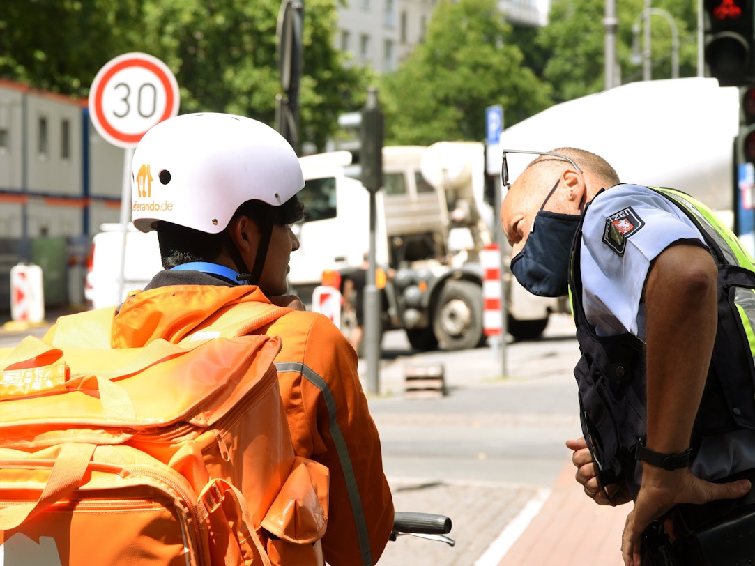 Ein Polizist spricht mit einem Essenslieferanten.