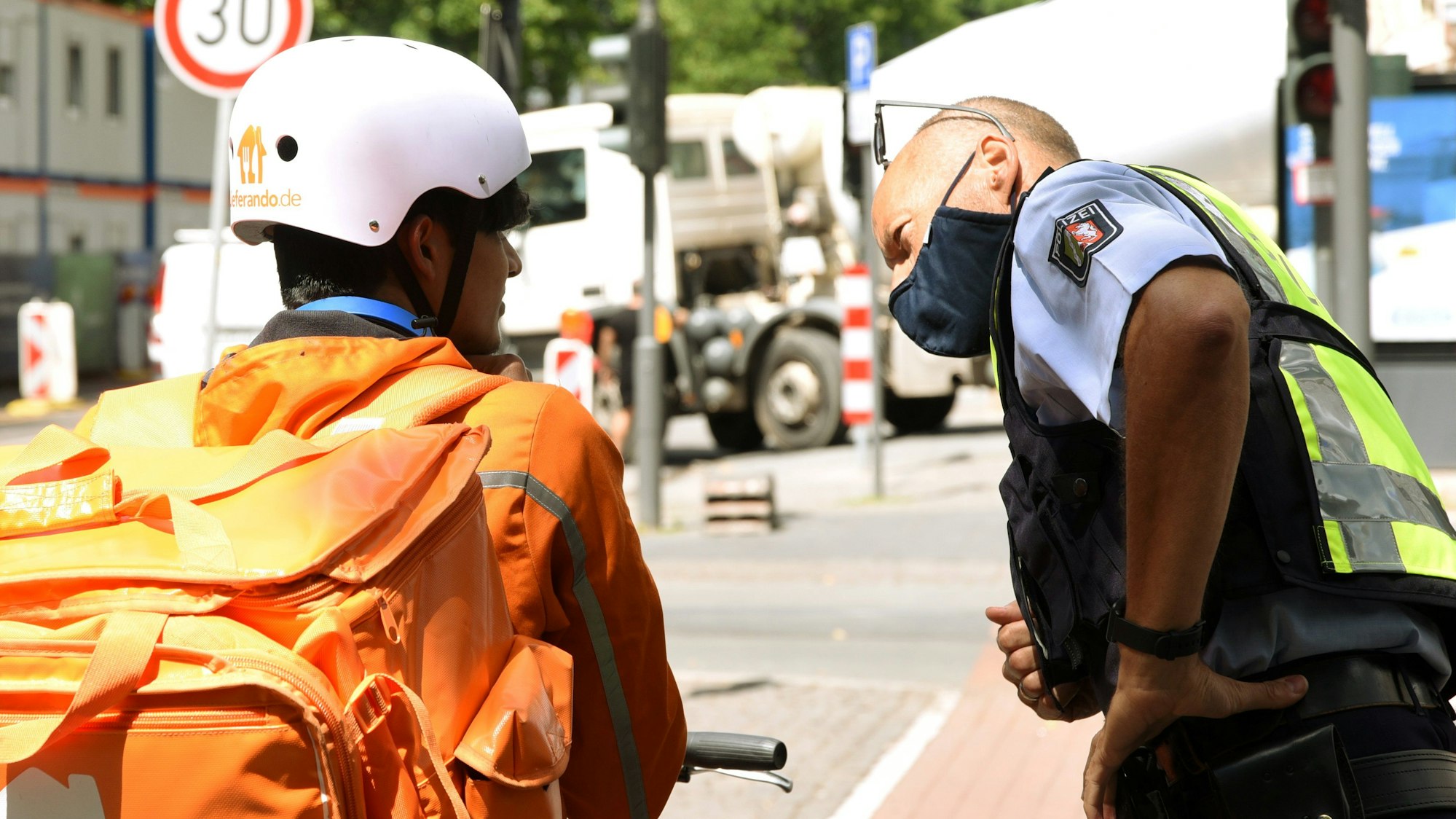 Ein Polizist spricht mit einem Essenslieferanten.