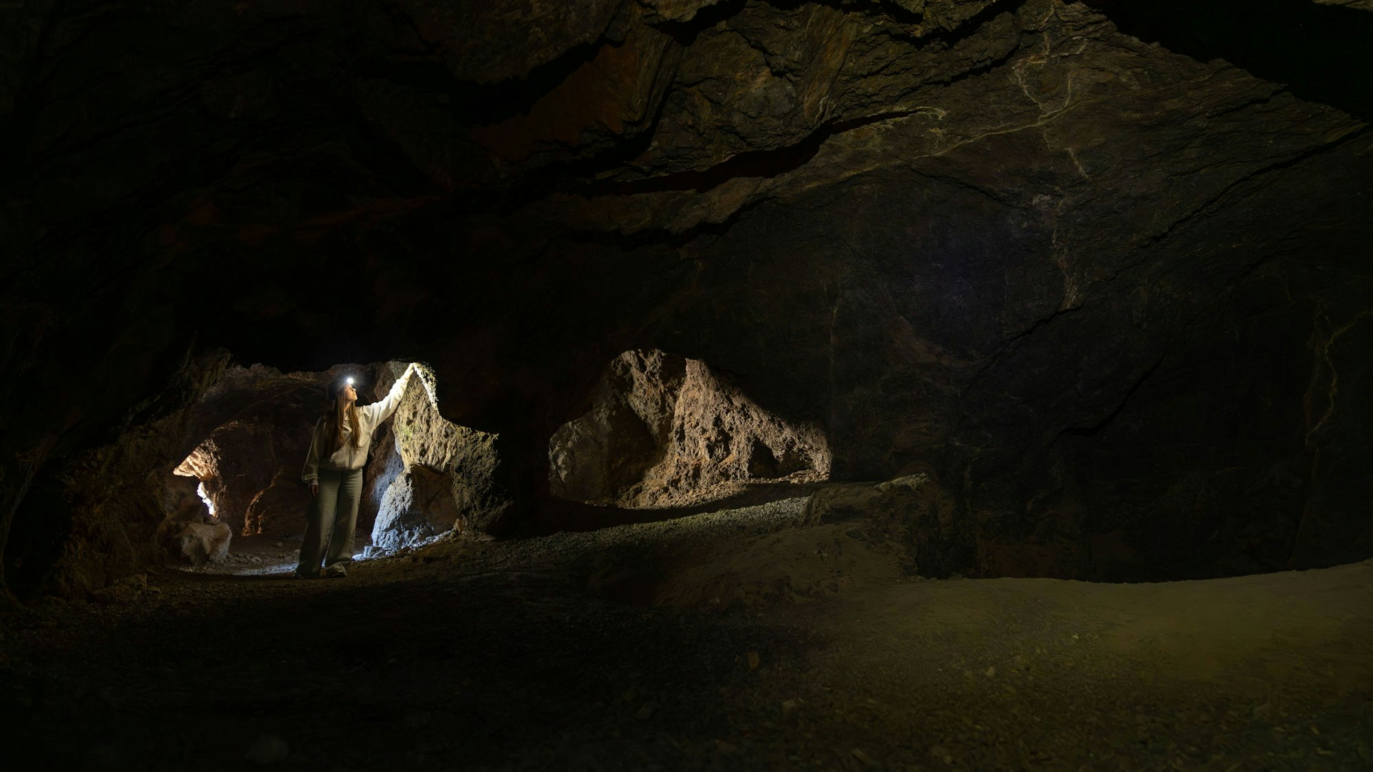 Frau erkundet dunkle unterirdische Höhle.