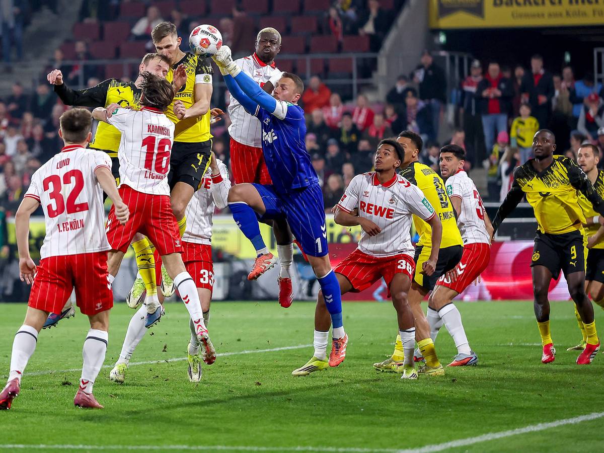 Torwart Marvin Schwäbe (1. FC Köln) verteidigt im Strafraum gegen Maximilian Beier und Nico Schlotterbeck (Borussia Dortmund).