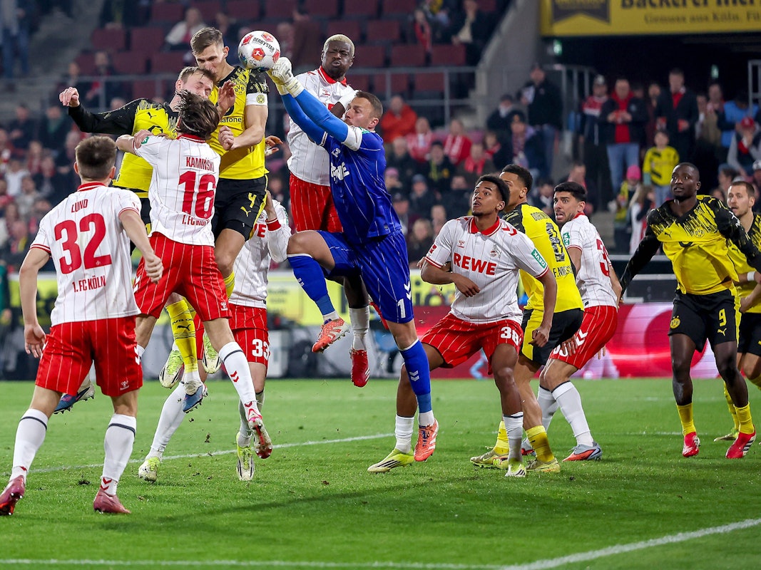 Torwart Marvin Schwäbe (1. FC Köln) verteidigt im Strafraum gegen Maximilian Beier und Nico Schlotterbeck (Borussia Dortmund).