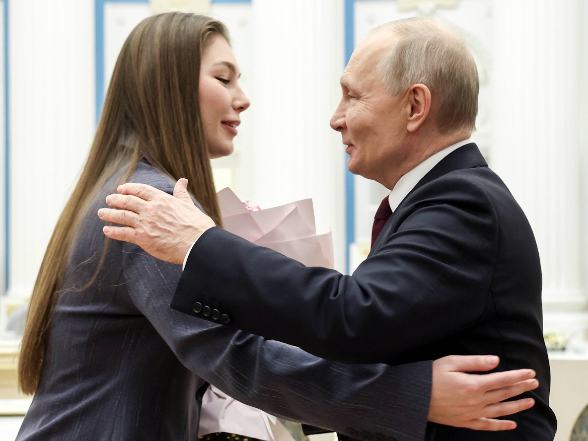 Der russische Präsident Wladimir Putin umarmt die Kriegsberichterstatterin und Fernsehmoderatorin Maryana Naumova während eines Treffens mit Frauen aus verschiedenen Berufsfeldern im Kreml am 5. März.