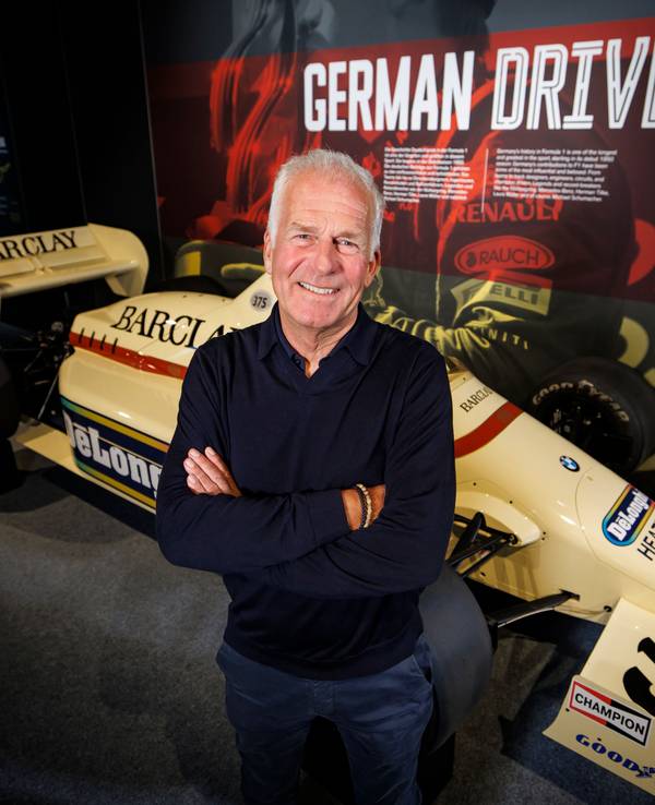 Christian Danner posiert in Oberhausen vor einem F1-Auto.