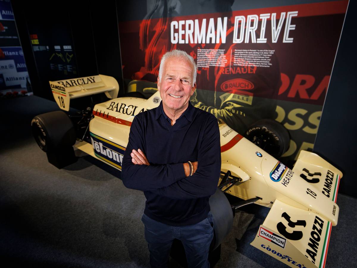 Christian Danner posiert in Oberhausen vor einem F1-Auto.