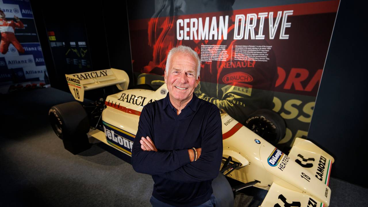 Christian Danner posiert in Oberhausen vor einem F1-Auto.
