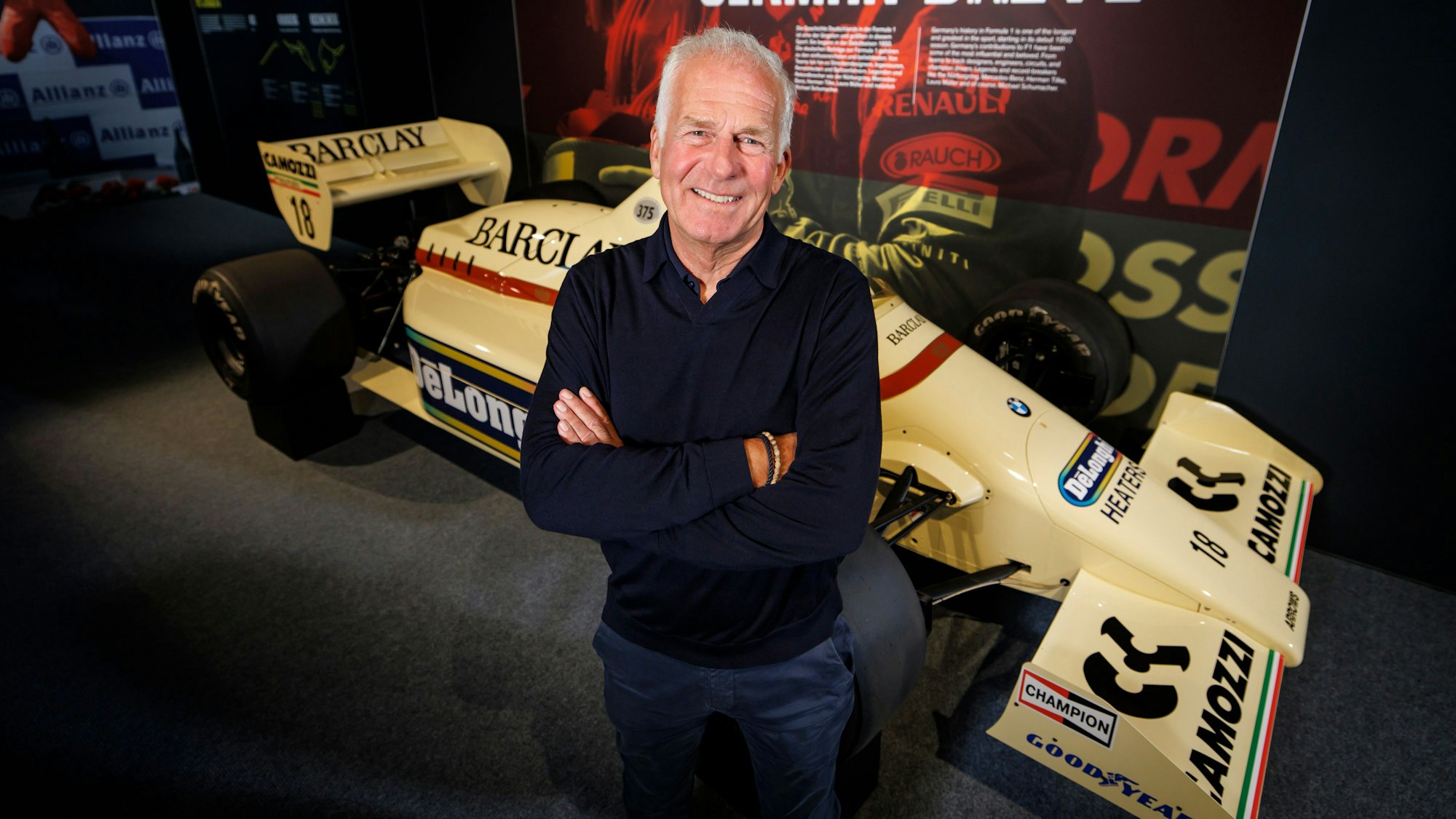 Christian Danner posiert in Oberhausen vor einem F1-Auto.