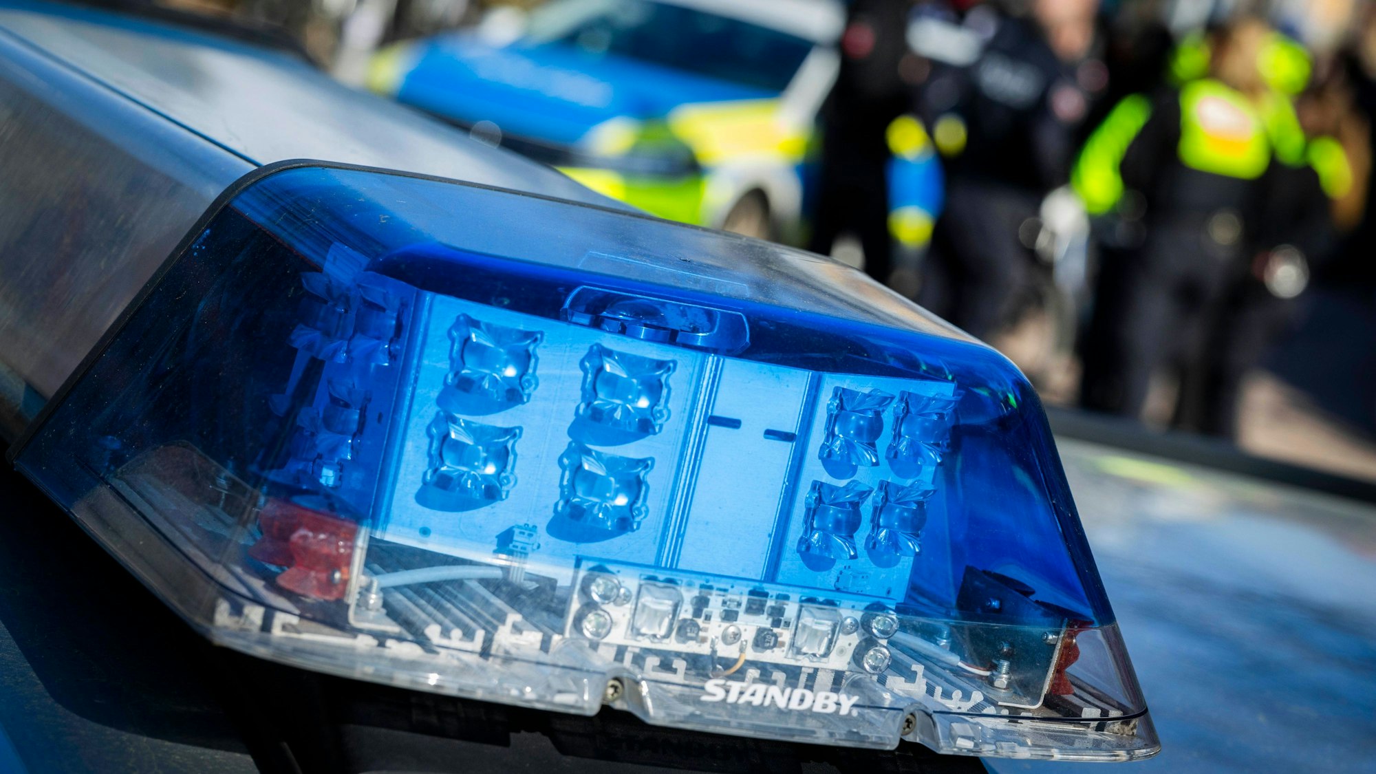 Blaulichtbalken Polizeiauto und Personen