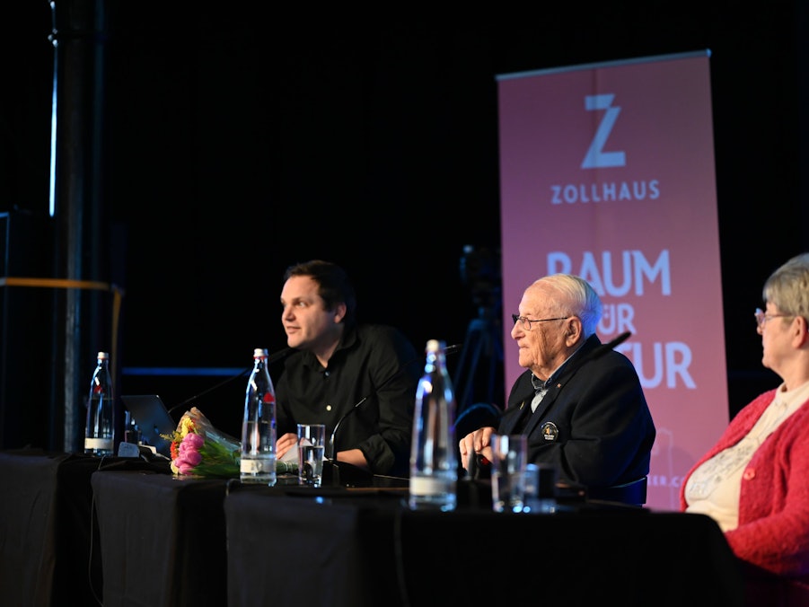 Albrecht Weinberg und zwei Personen auf Bühne