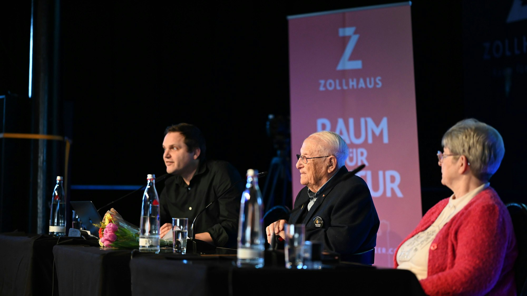 Albrecht Weinberg und zwei Personen auf Bühne