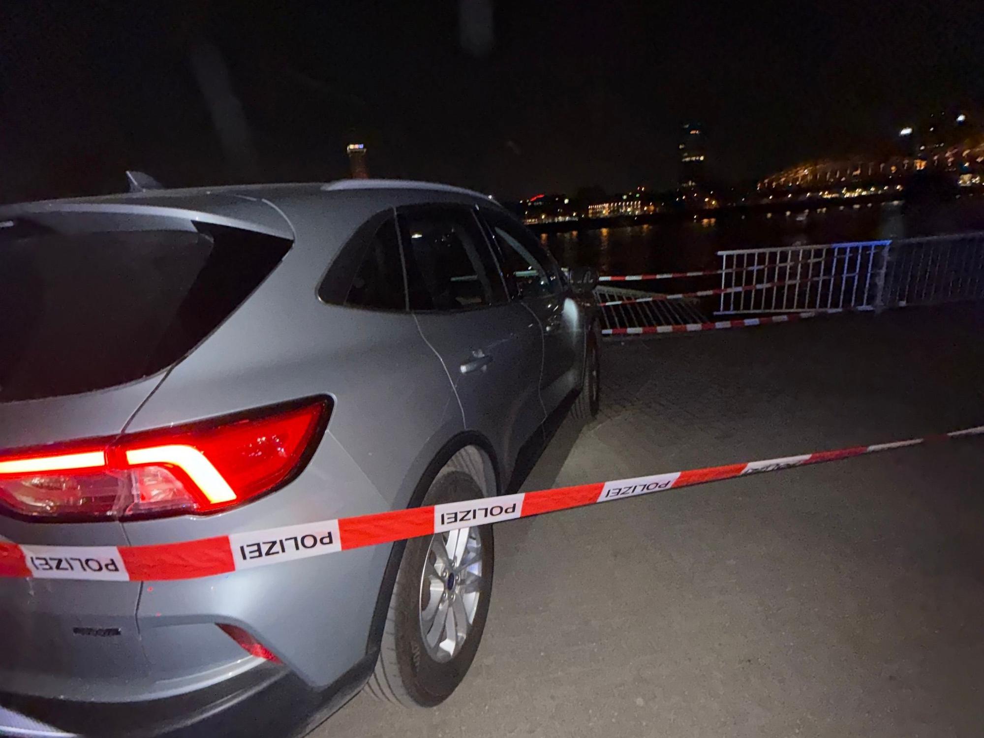 Ein Auto steht vor einer Unfallstelle am Kölner Rheinufer
