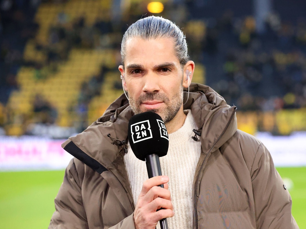 Daniel Herzog steht mit DAZN-Mikro im Stadion.