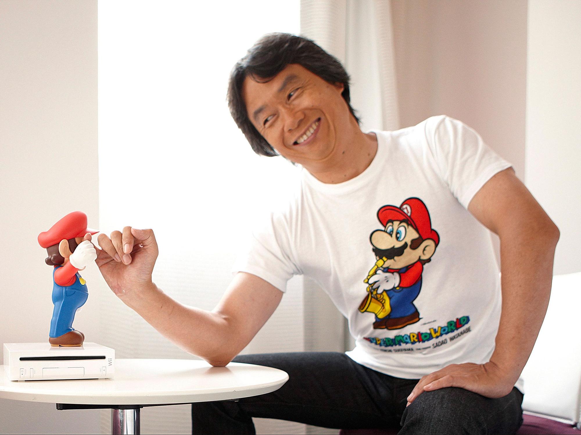 Ein asiatisch aussehender Mann klatscht sich mit einer kleinen Spielfigur ab.