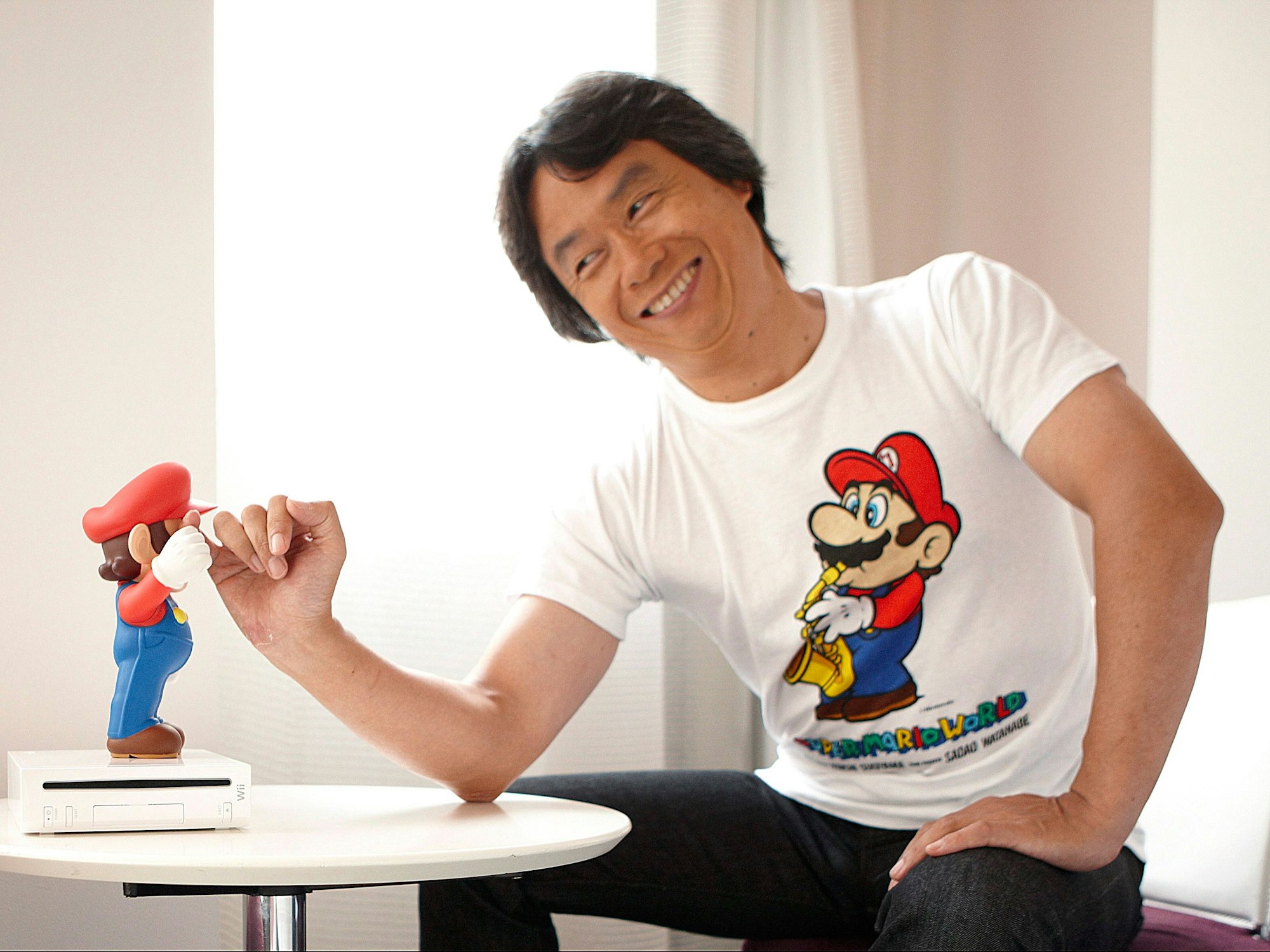 Ein asiatisch aussehender Mann klatscht sich mit einer kleinen Spielfigur ab.