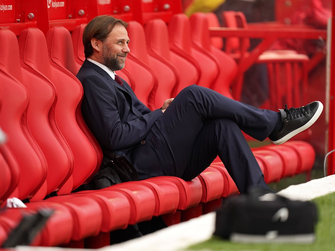 Tim Steidten sitzt lächelnd auf der leeren Ersatzbank.