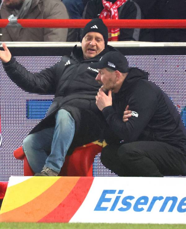 Trainer Steffen Baumgart hockt zusammen mit Union-Geschäftsführer Horst Heldt am Arande eines Bundesligaspiels.