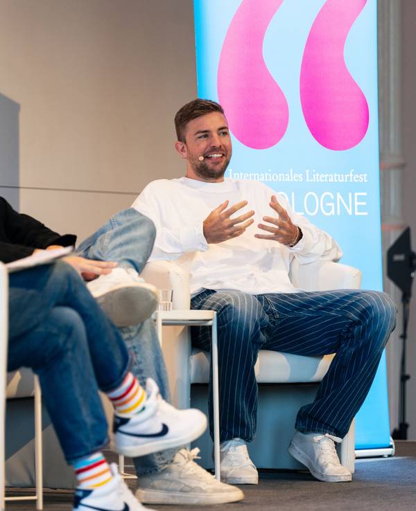 Christoph Kramer sitzt bei der lit.Cologne auf der Bühne.