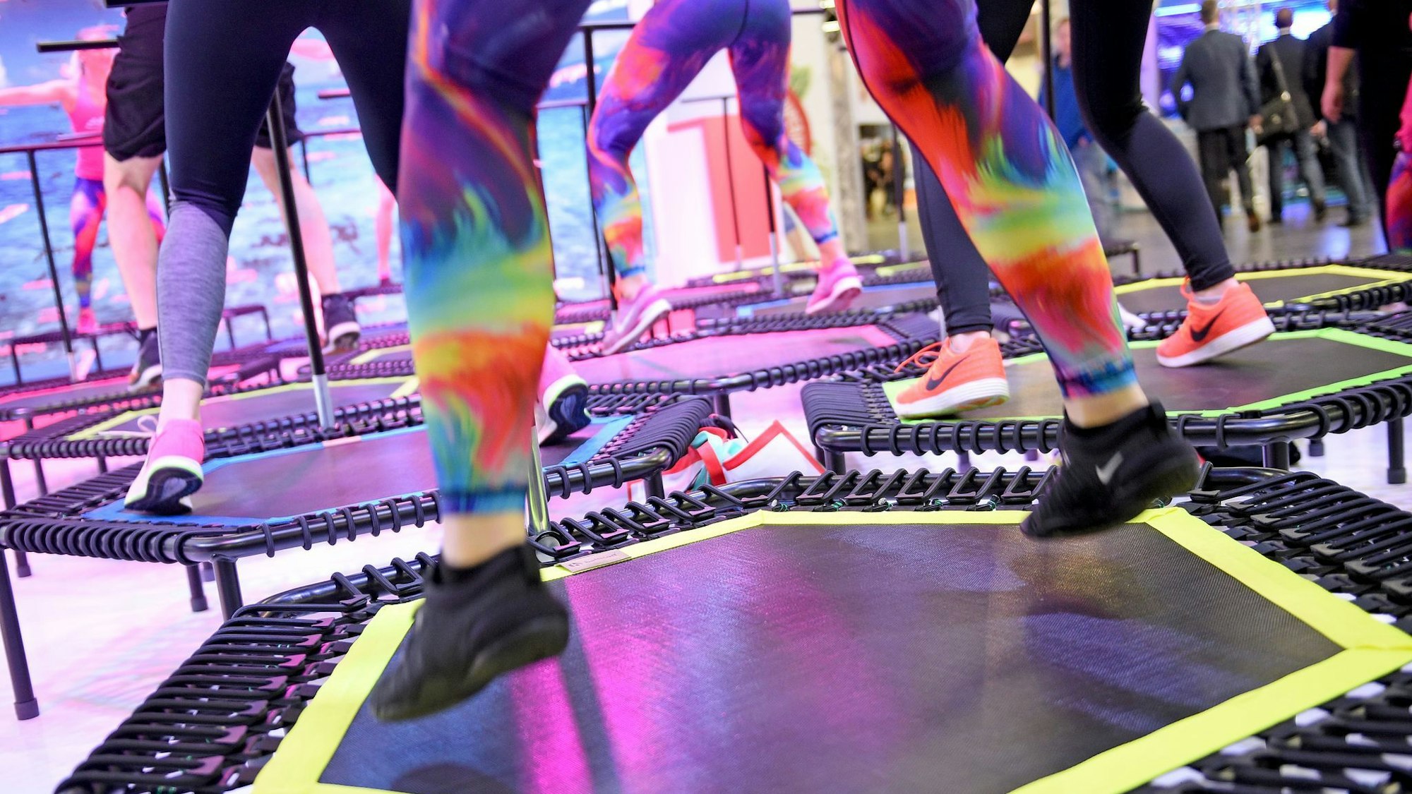 Personen trainieren auf Trampolinen