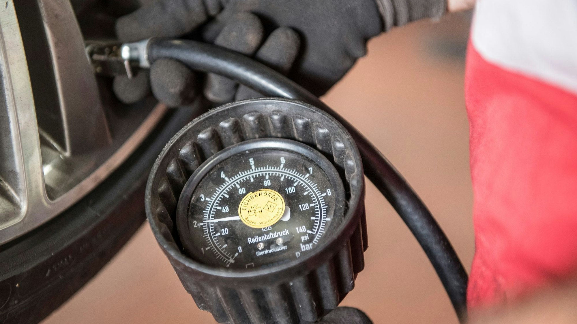 Kfz-Mechatroniker prüft den Reifendruck eines reifens