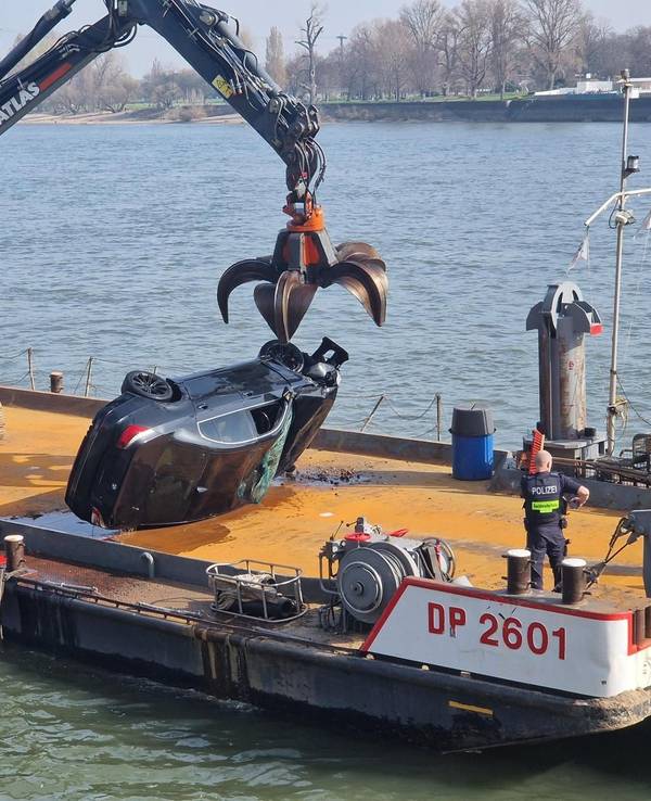 Ein Pkw liegt seitlich auf dem Deck eines Schiffes.