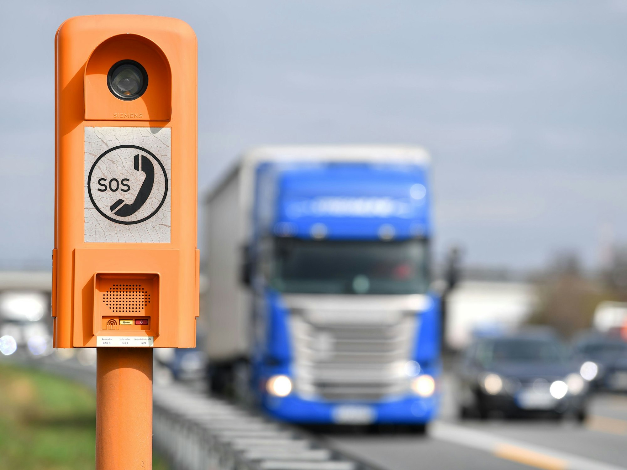 Ein Lastwagen fährt auf der A5 (Hessen) an einer Notrufsäule vorbei.