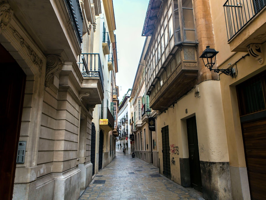 Enge Straße mit Gebäuden und wenigen Menschen