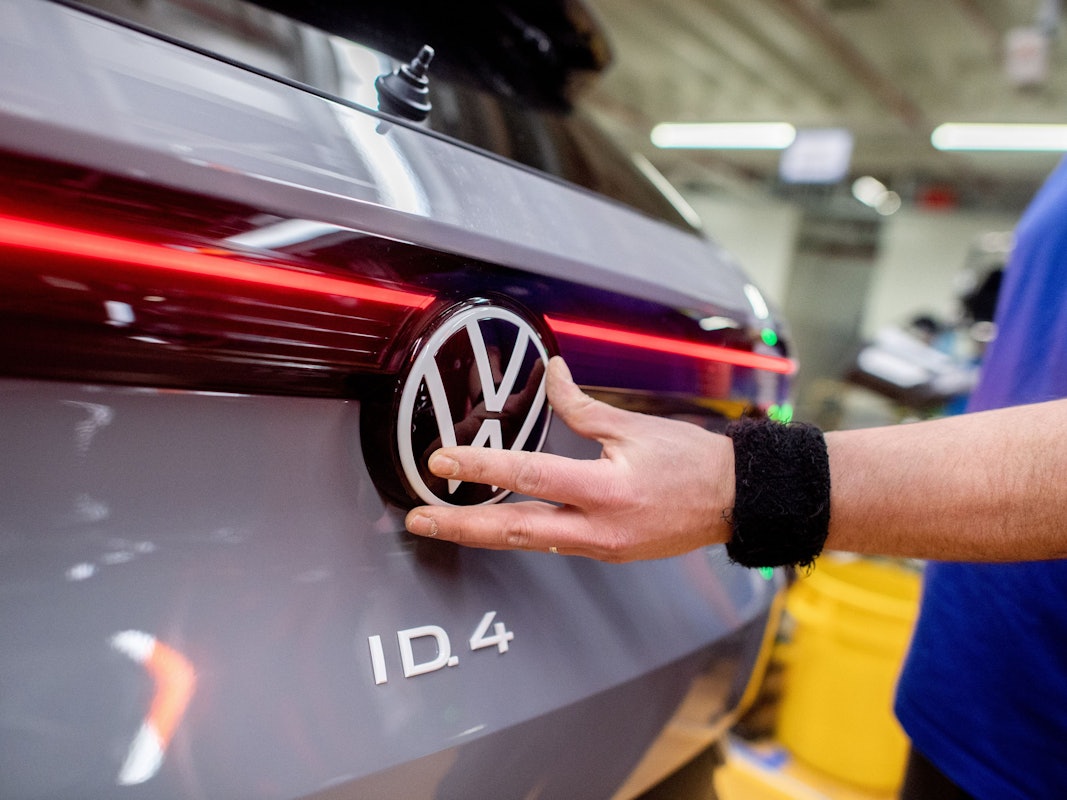 Ein Mitarbeiter setzt im Werk von Volkswagen das Logo der Marke an einem Fahrzeug vom Typ ID.4 ein. Der VW-Konzern präsentiert am Dienstag in Wolfsburg seine Bilanz für 2025.