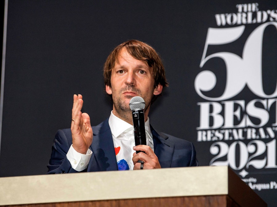 Rene Redzepi spricht am Mikrofon vor Hintergrundschriftzug