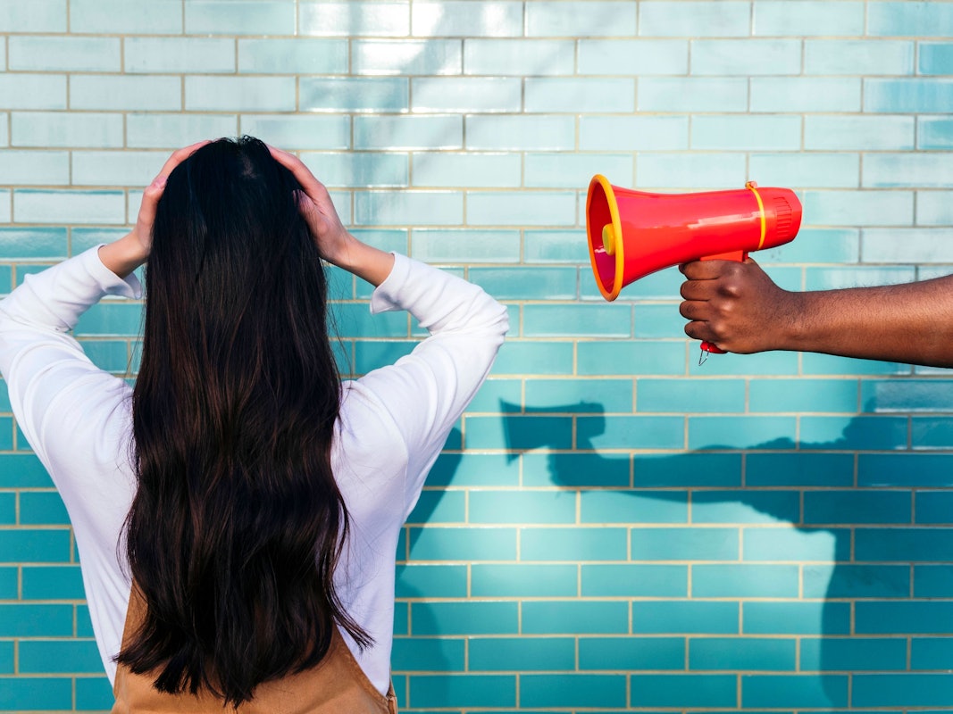 Ein Mann hält einer Frau ein Megaphon ans Ohr.