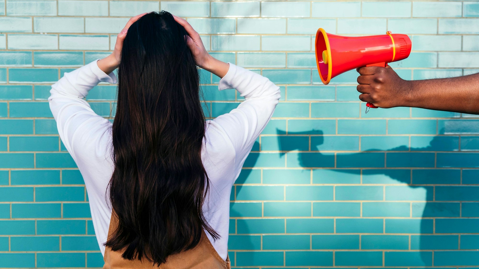 Ein Mann hält einer Frau ein Megaphon ans Ohr.