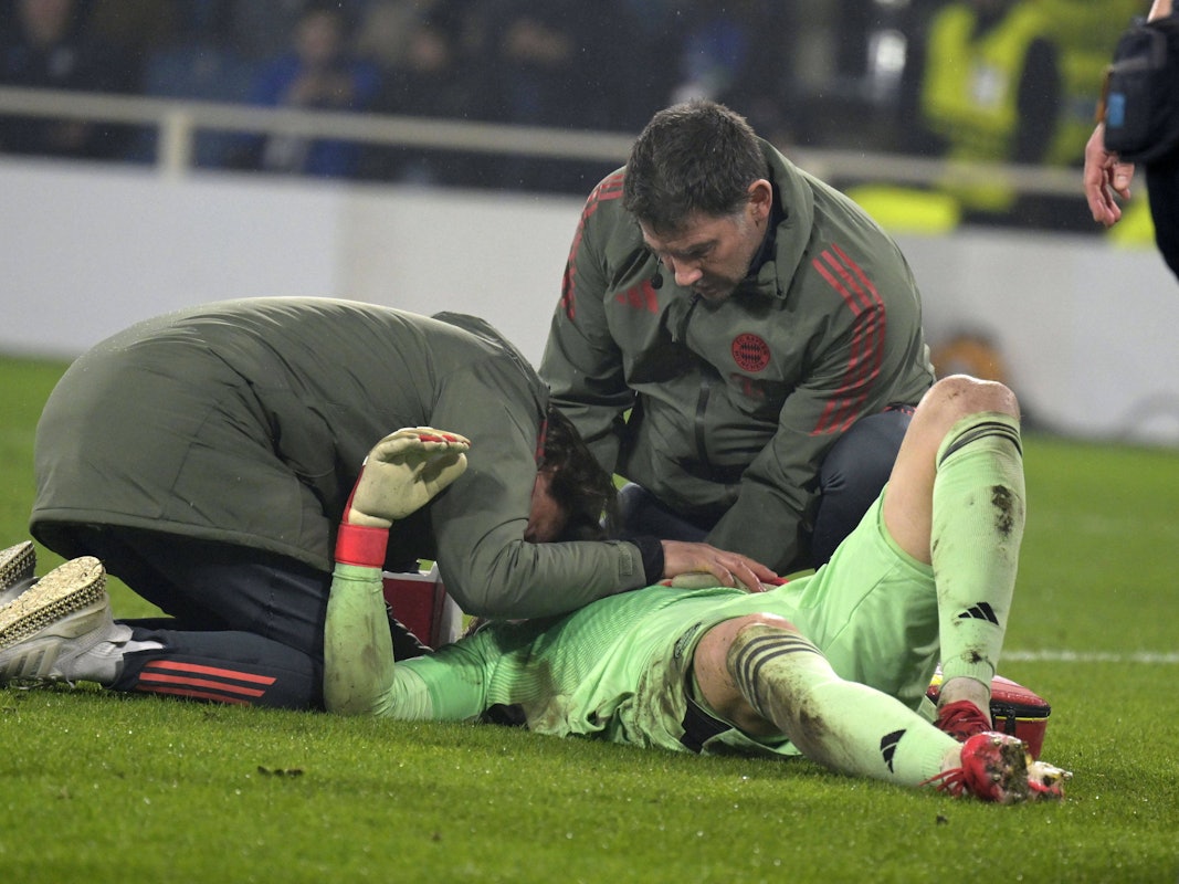Jonas Urbig liegt auf dem Rasen und wird behandelt.