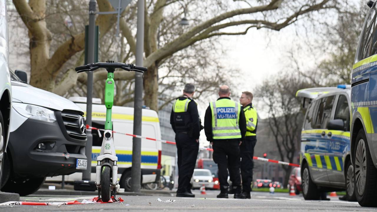 Polizeikräfte stehen an einer abgesperrten Straße.