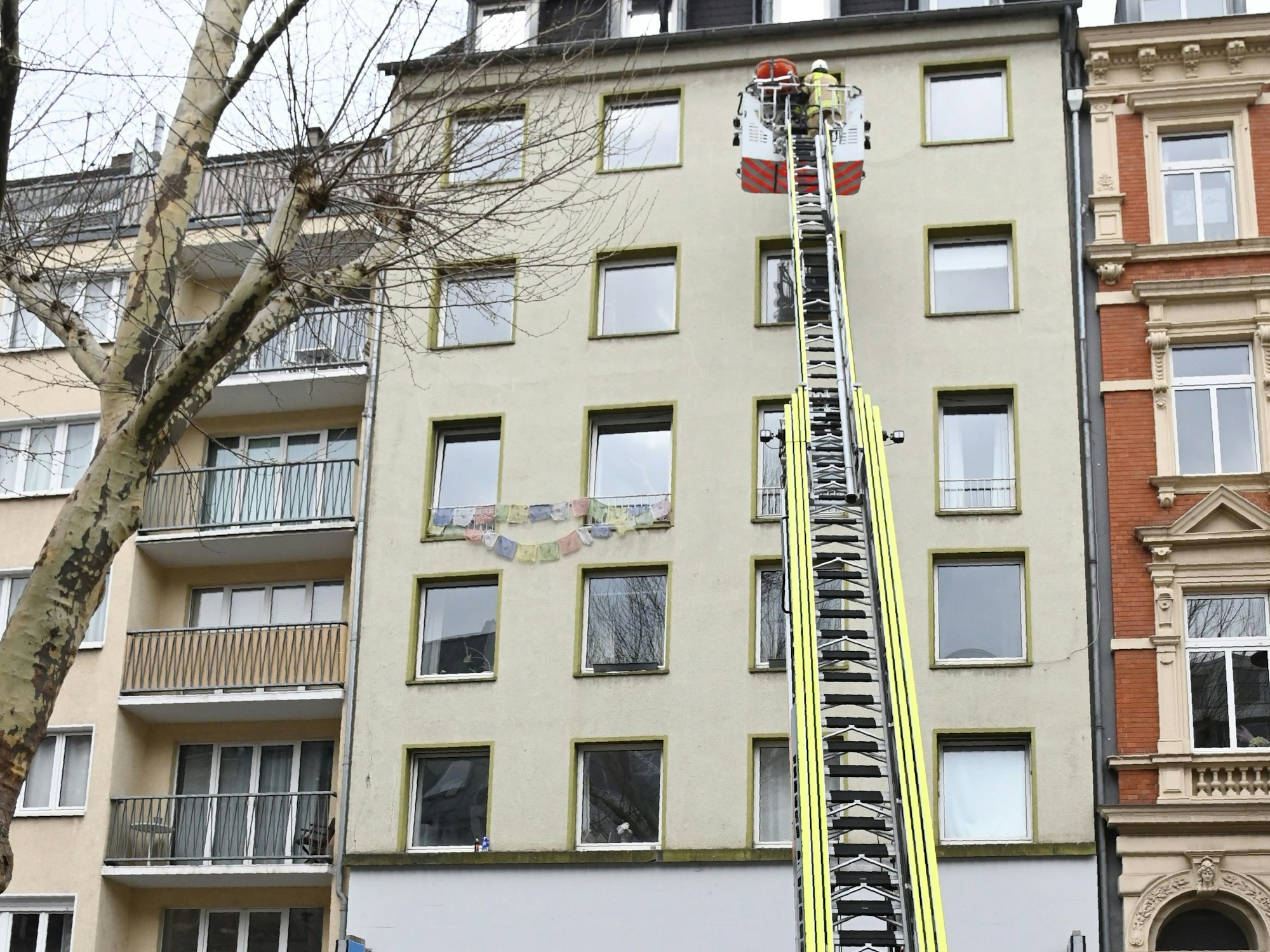 Eine Drehleiter ist bis zu einem Fenster im sechsten Stock eines Hauses ausgefahren.