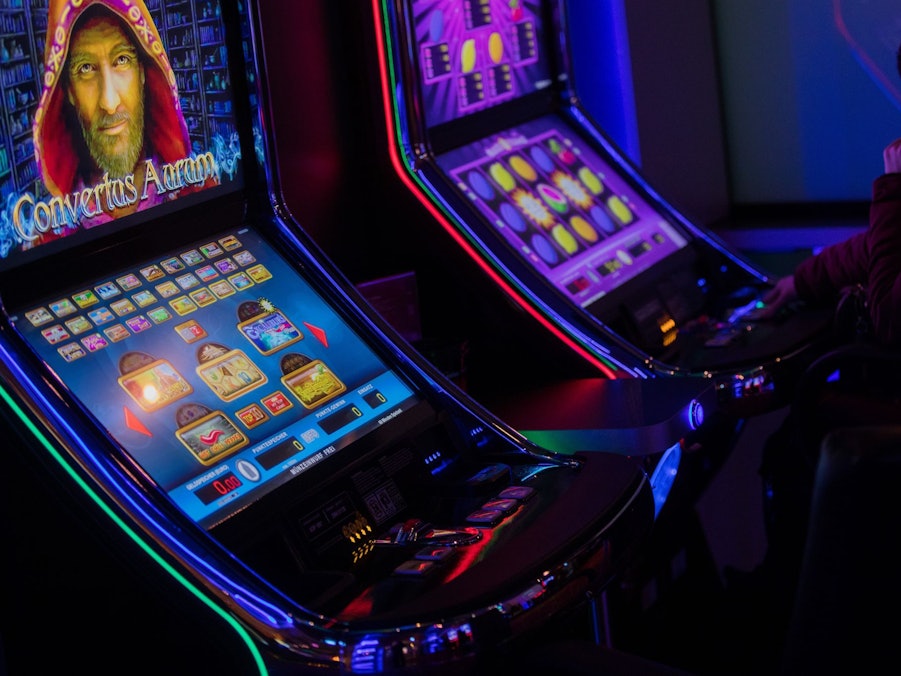 Eine Person sitzt an einem Spielautomaten