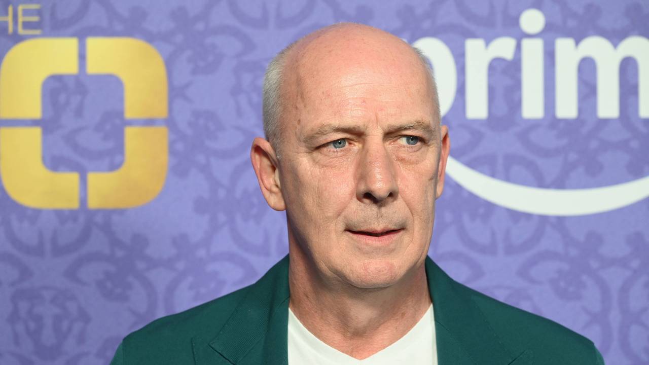 Mario Basler im grünen Sakko vor unscharfem Hintergrund