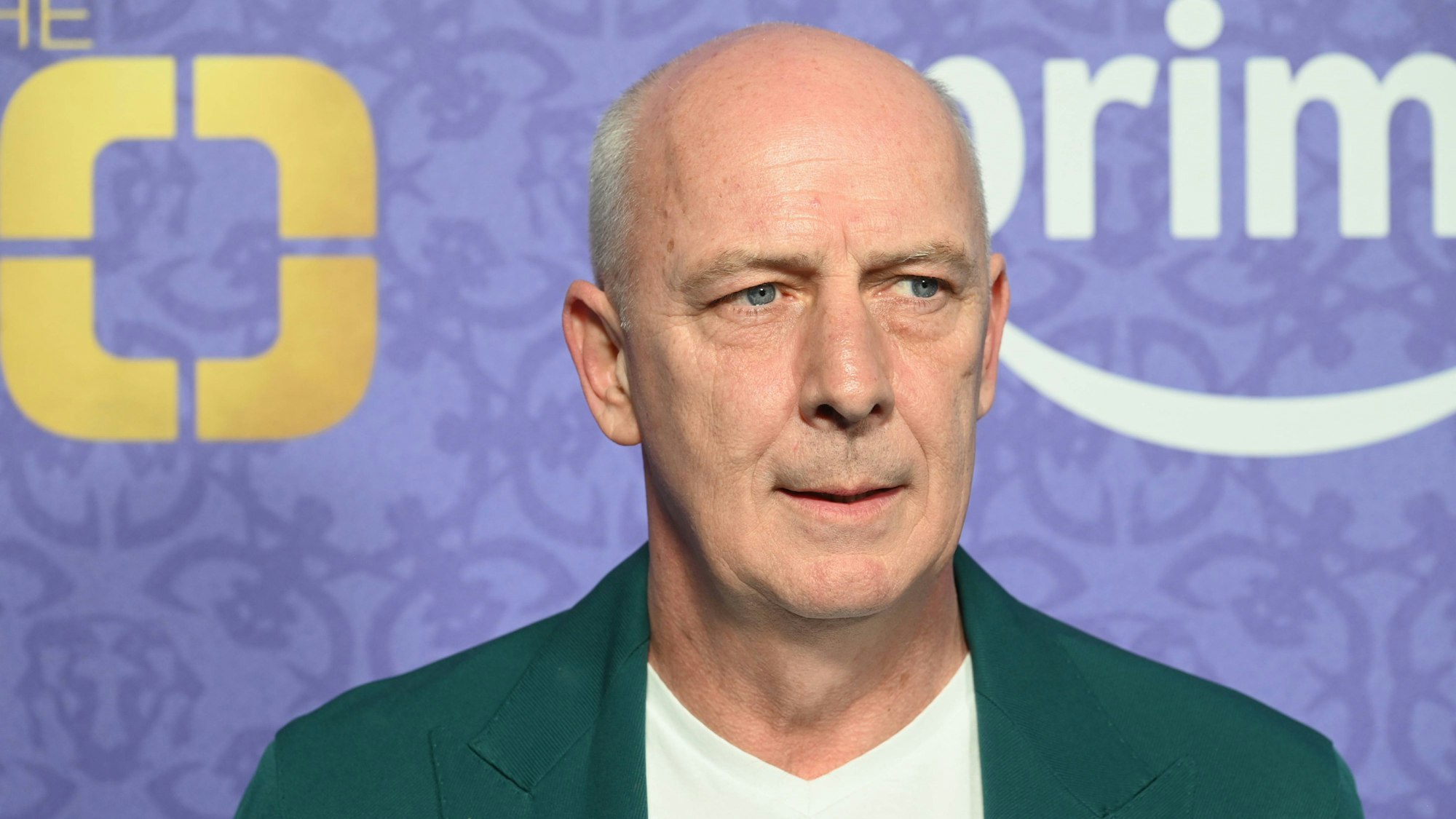 Mario Basler im grünen Sakko vor unscharfem Hintergrund