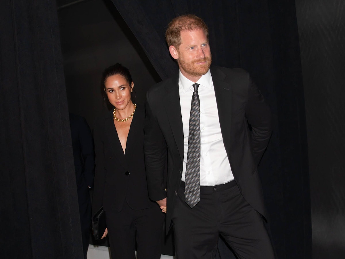 Meghan Markle und Prinz Harry gehen durch einen Vorhang.