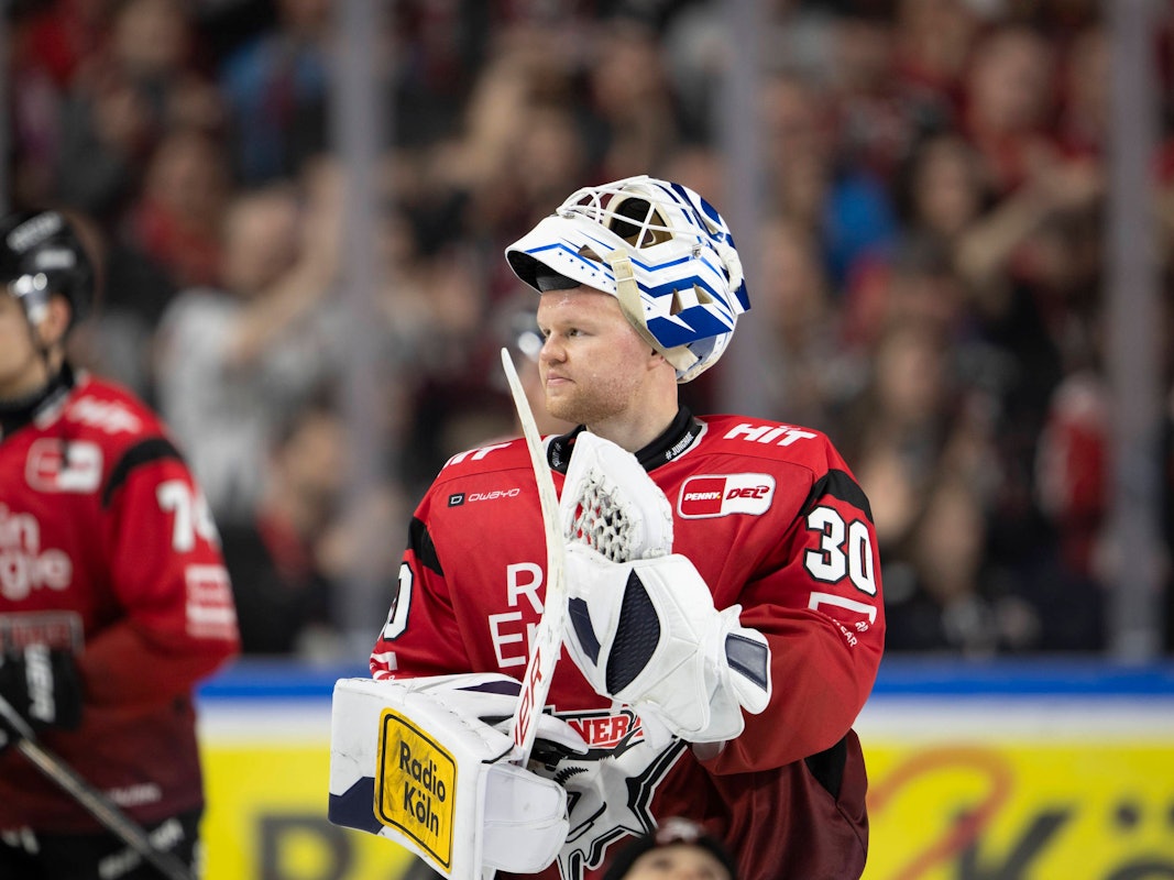 KEC-Goalie Janne Juvonen hat die Maske hochgezogen und applaudiert mit seinem Schläger.