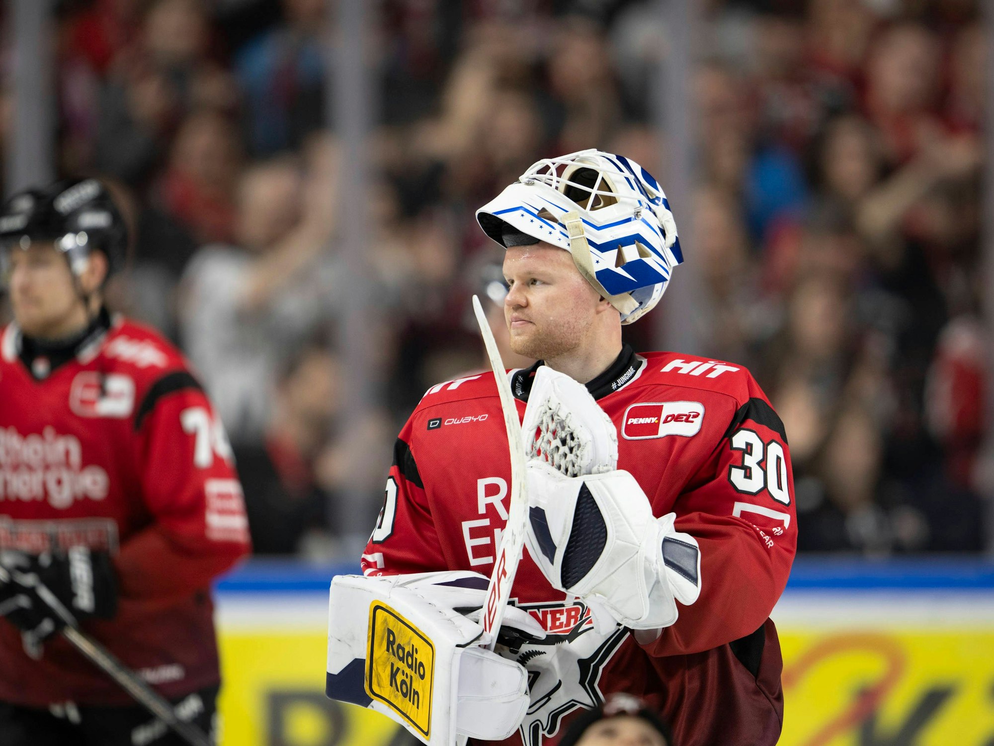 KEC-Goalie Janne Juvonen hat die Maske hochgezogen und applaudiert mit seinem Schläger.