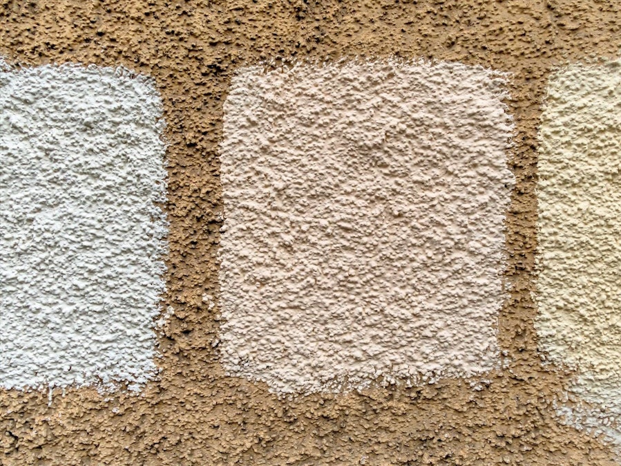 Drei Farbmuster an einer strukturierten Wand