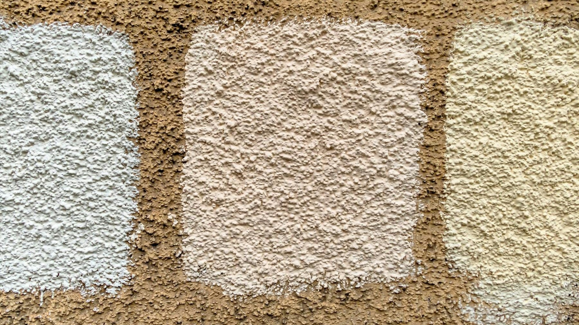 Drei Farbmuster an einer strukturierten Wand