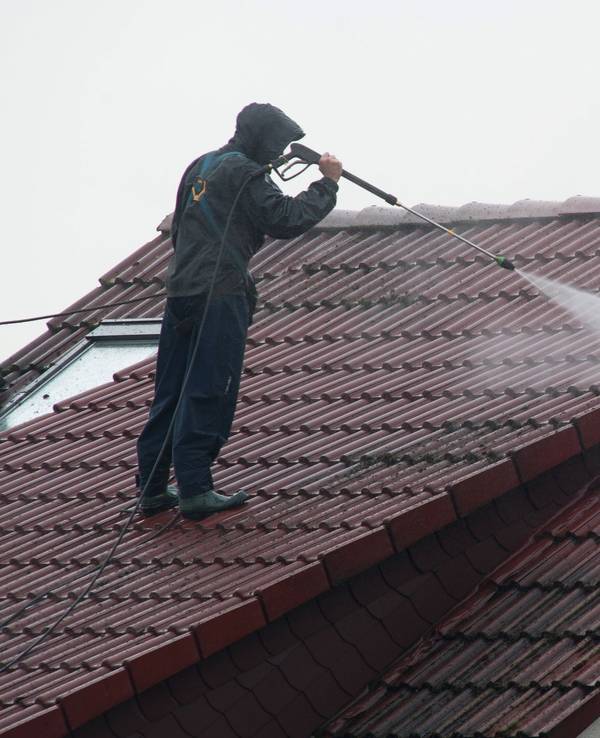 Arbeiter reinigen das Dach eines Hauses