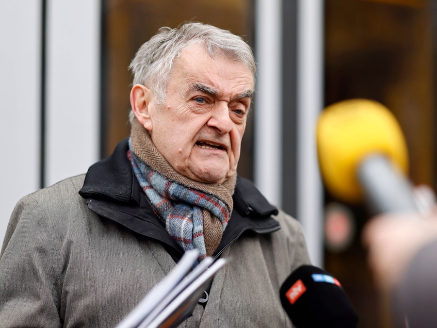 Mann mit Schal spricht in Mikrofone