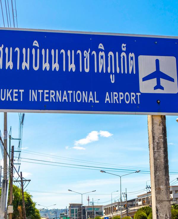 Schild zum Flughafen Phuket unter blauem Himmel