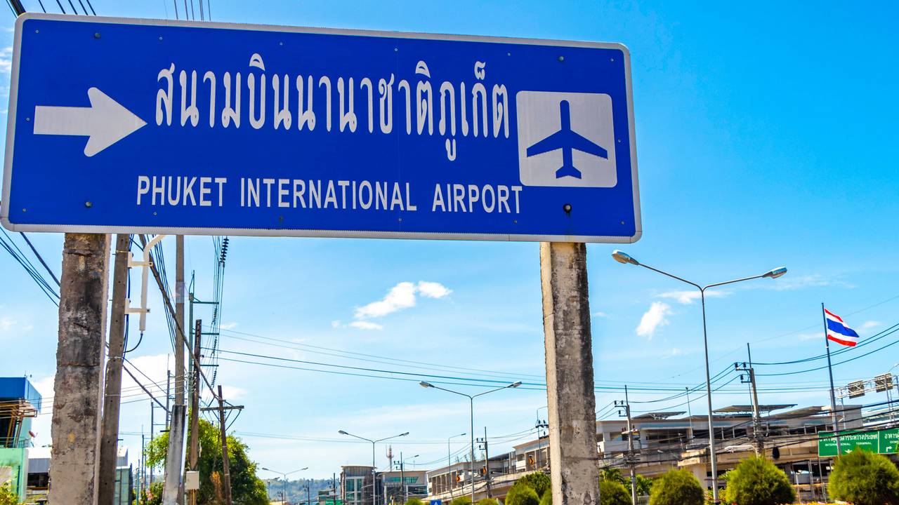 Schild zum Flughafen Phuket unter blauem Himmel